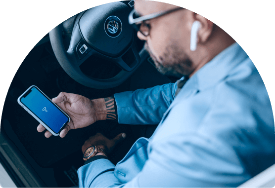 homem no carro segurando o celular com o app da turbi